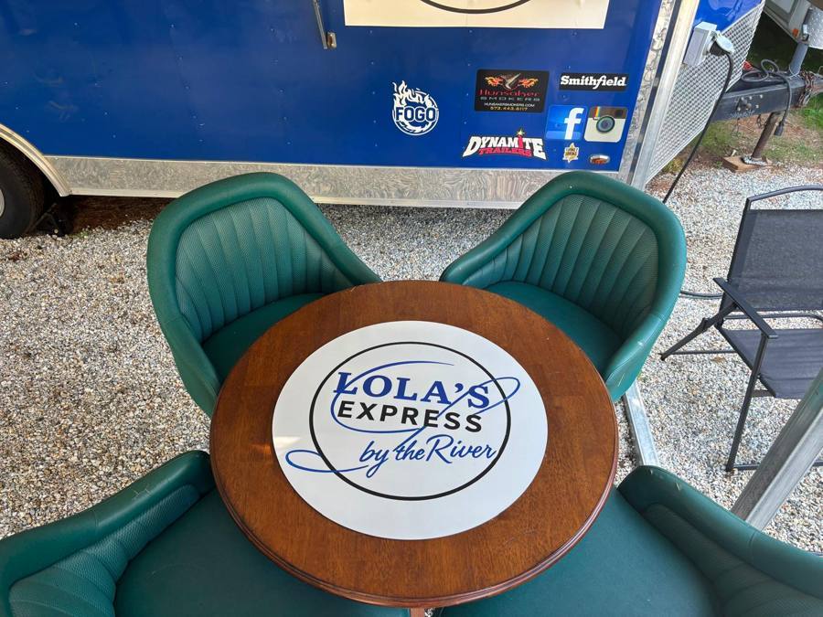 Table with the Lola's Express logo beside the Lola's Express kitchen